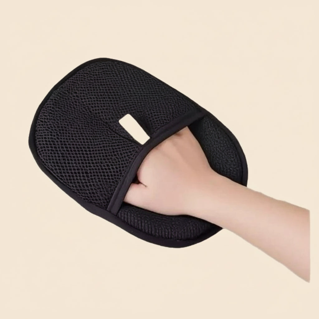 Black mesh bath glove being worn on a hand against a white background
